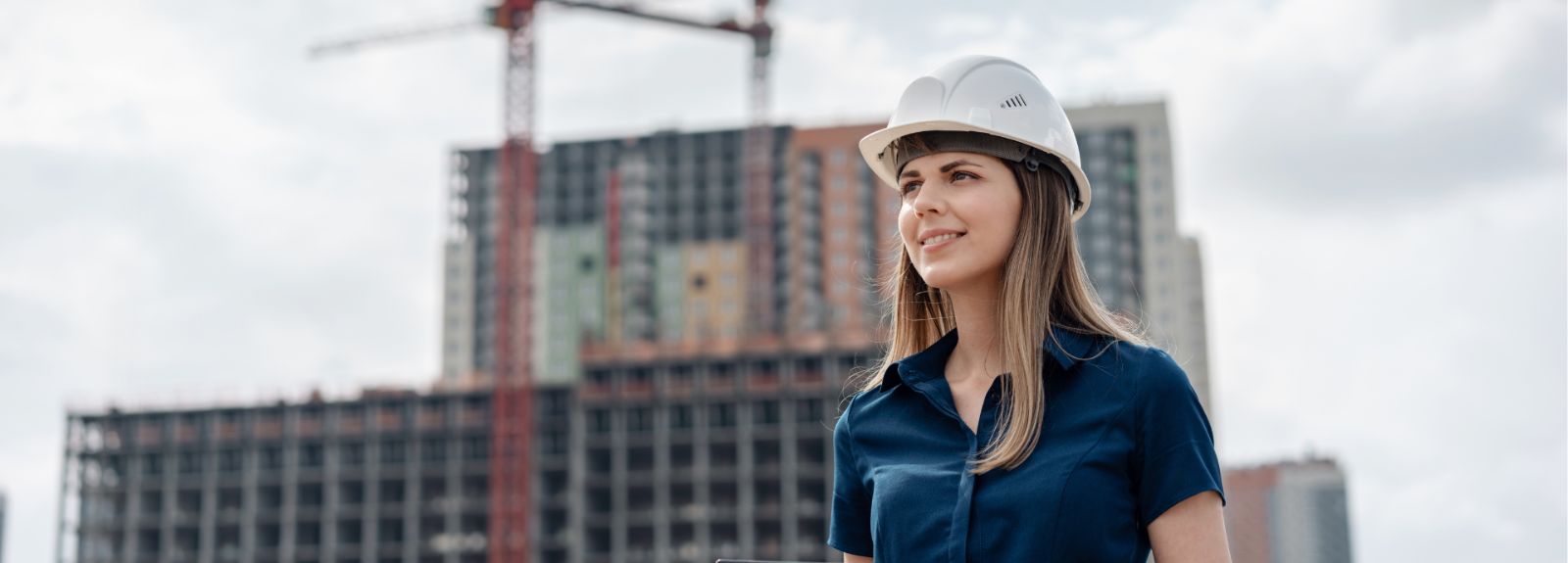 female student standing on a building roof wearing a hard hat